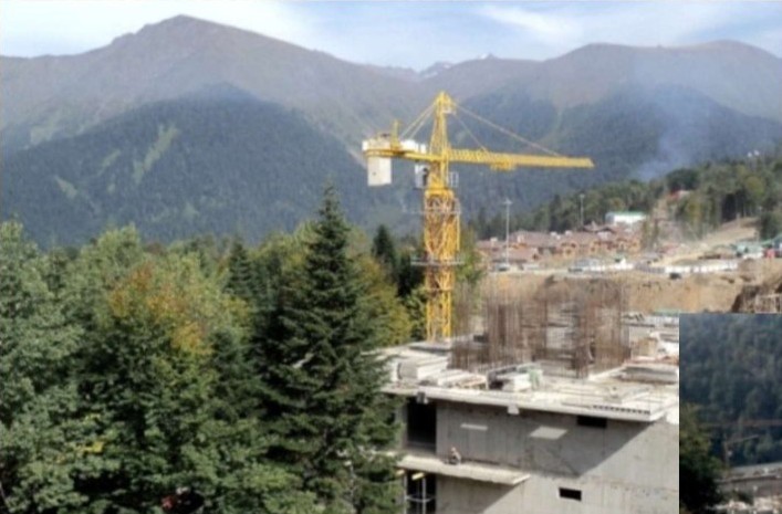 Heavy crane lifting refinery equipment on a construction site